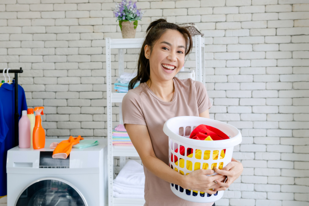 Mulher carregando cesto em lavanderia. Imagem ilustrativa para texto Organizar lavanderia.