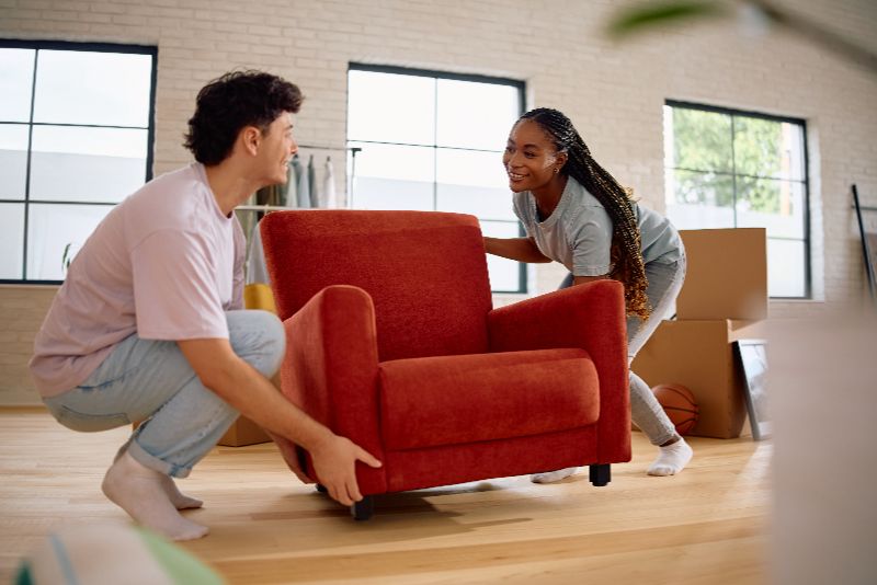 Casal feliz carregando móveis para sua nova casa.