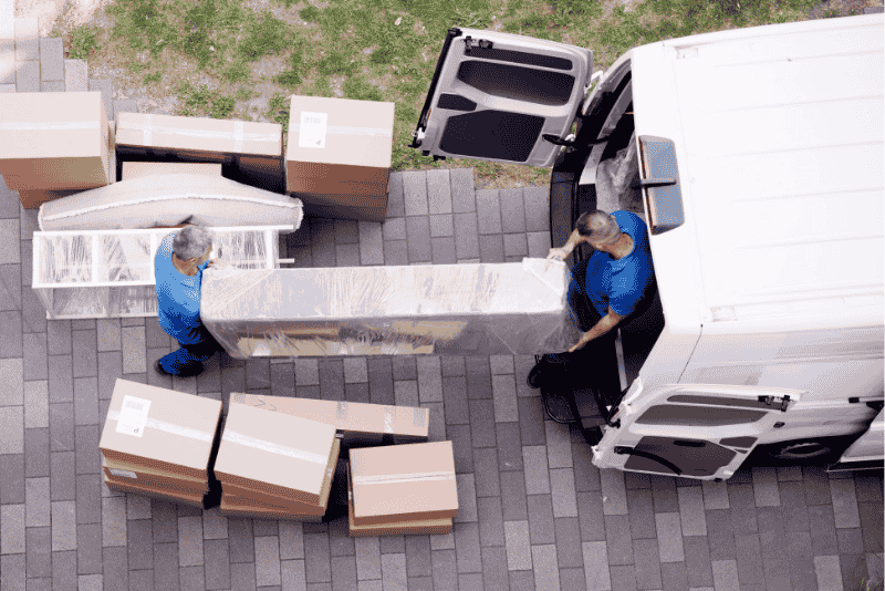 Homens colocando moveis em van para mudança