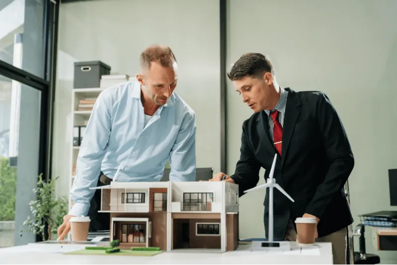 Homens analisando projeto em mequete
