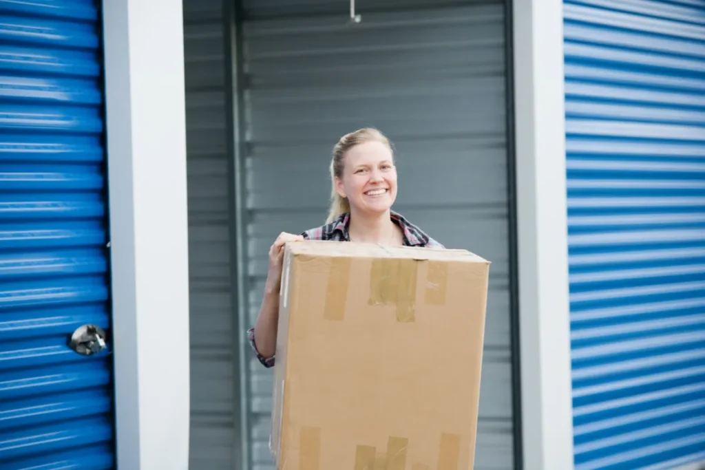 mulher sorridente carregando caixas para o self storage