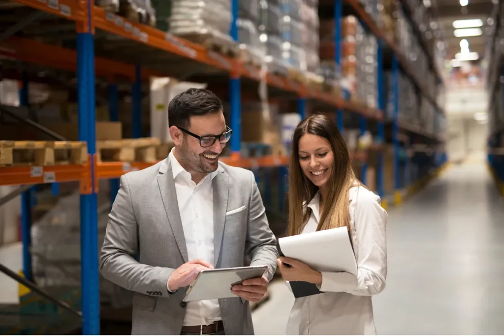 Homem e mulher sorridentes dorante trabalho em estoque empresarial