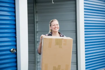 mulher sorridente carregando caixas para o self storage