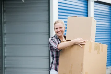 Mulher sorridente segurando caixas de papelão