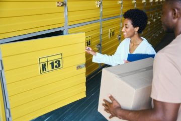 Jovem casal guardando caixas de documentos em um self storage